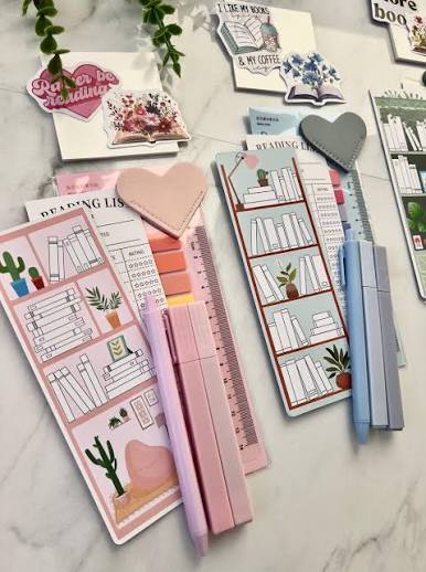 Pastel annotation tools and reading trackers arranged on a desk